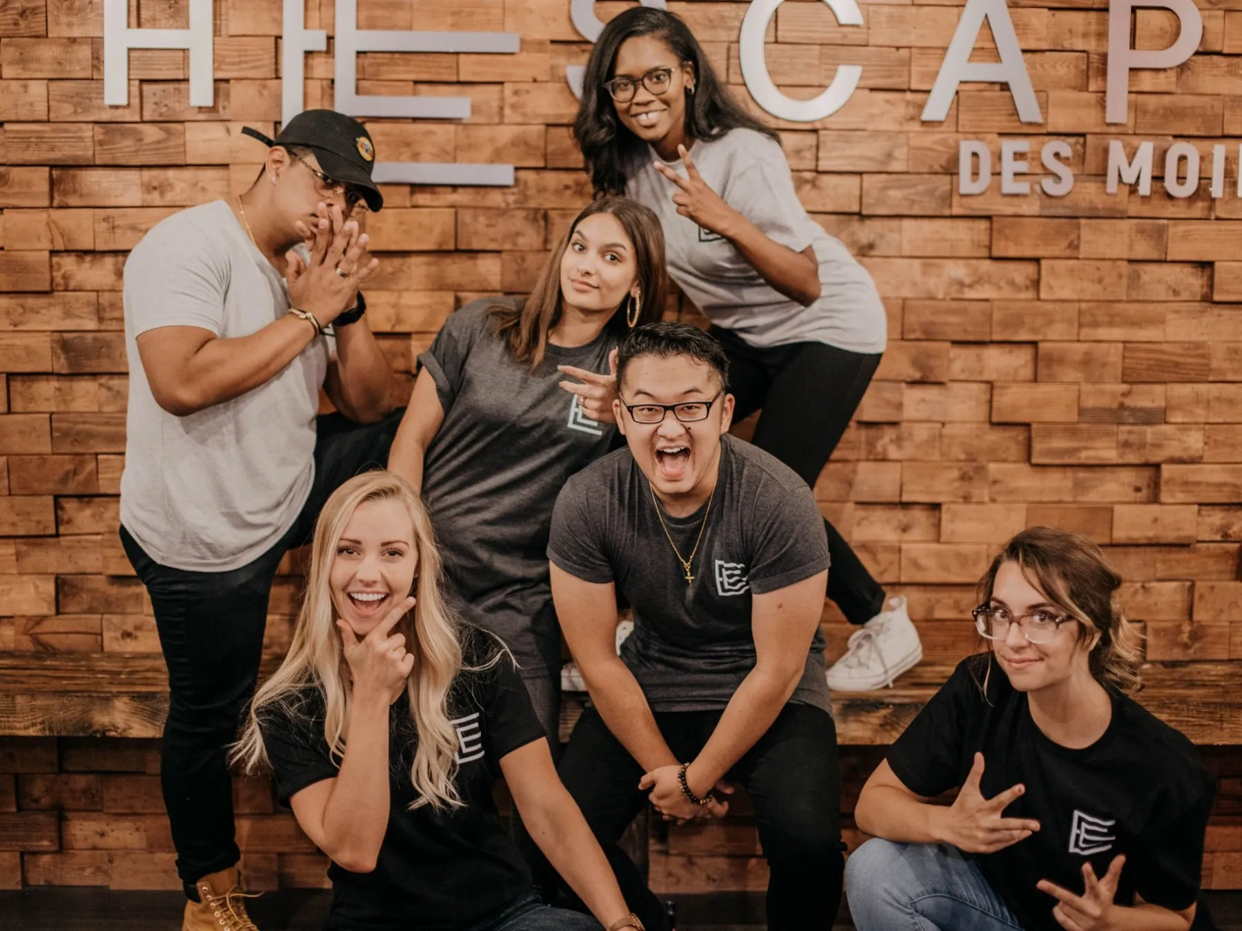 a group of people posing for a photo in front of a brick wall